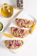 Toast with Canned Tuna. Fish open sandwich with avocado, red onion and lemon. 