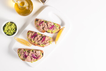 Toast with Canned Tuna. Fish open sandwich with avocado, red onion and lemon. 