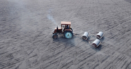 Aerial view of tractor preparing land for sowing in the field