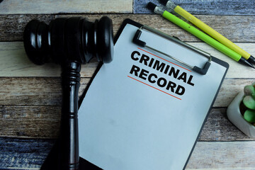 Concept of Criminal Record write on paperwork with gavel isolated on wooden background.