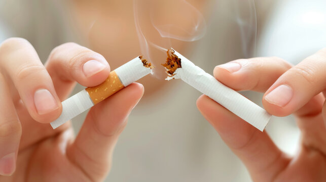 Hands are shown breaking a cigarette in half, symbolizing the decision to quit smoking and lead a healthier lifestyle.