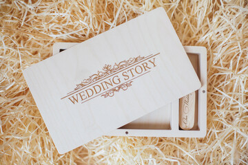 Wooden photo box for photo storage on straw background. open Box with flash with laser engraving...