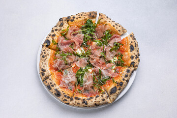 Pizza with prosciutto, arugula and parmesan