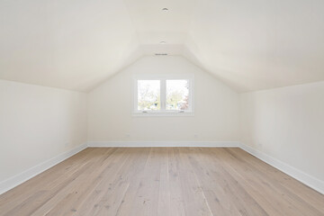 Versatile Empty Room with Blond Hardwood Floors and Cream Walls for Virtual Staging. Bedroom, Finished Attic, Sloped Ceiling.