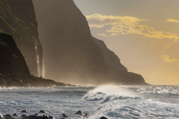 Volcanic rock cliffs Achadas da Cruz in backlit sunlight. Waves of the Atlantic Ocean. Beautiful...