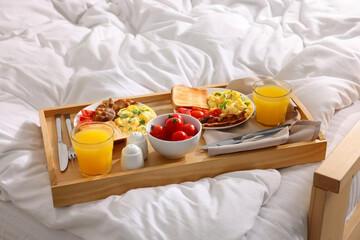 Good morning. Tray with tasty breakfast on bed