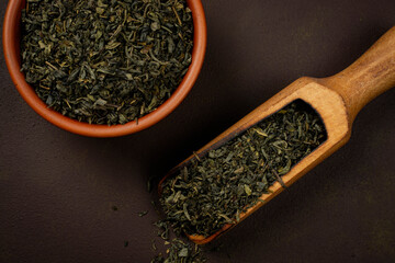 Bowl and wooden scoop with green tea.