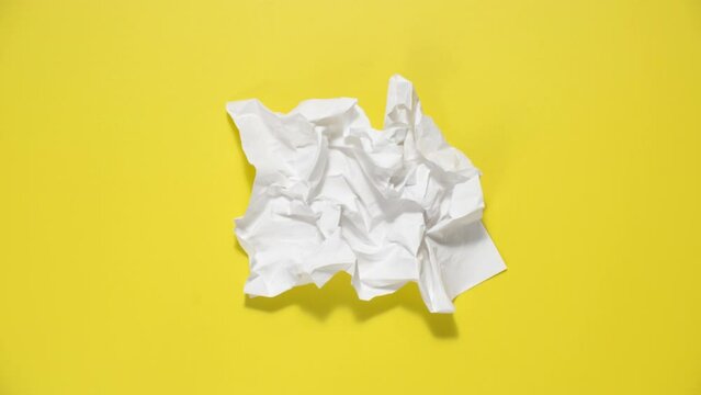 Stop motion animation of crumpled paper, stop motion animation 4k, on a yellow background.