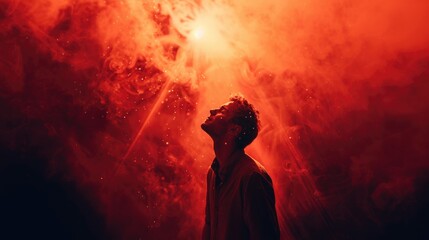 Portrait of a young man praying against a background of red smoke. Worship.