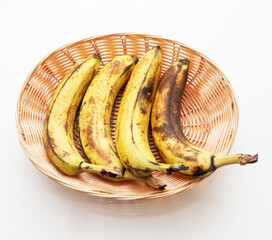 Ripe bananas in a straw basket in the kitchen. Delicious bananas.