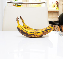 Banana on a white glossy kitchen table. Banana fruit in the kitchen.