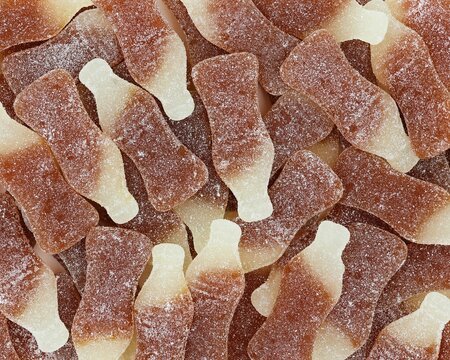 Candy in the shape of a coke bottle. Sugared candy. Background.