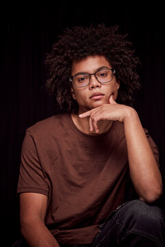 Studio portrait of young colored man with glasses on. Munich, Germany