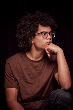 Studio portrait of young colored man with glasses on. Munich, Germany