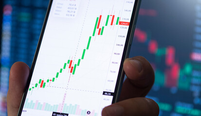 Crypto trader investor man using smart phone app financial stock trade market trading order to buy...