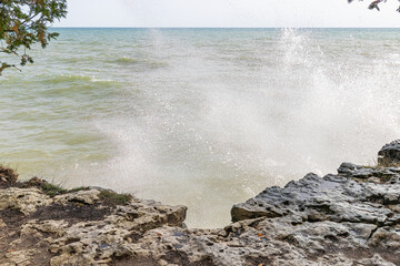Crashing waves on the eroded rocky shore of Lake Michigan Wisconsin, USA 