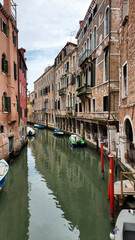 Fototapeta na wymiar Venice, vertical image of a gondola in a narrow canal