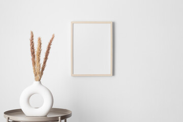 Wooden frame mockup on the wall with a pampas decoration.