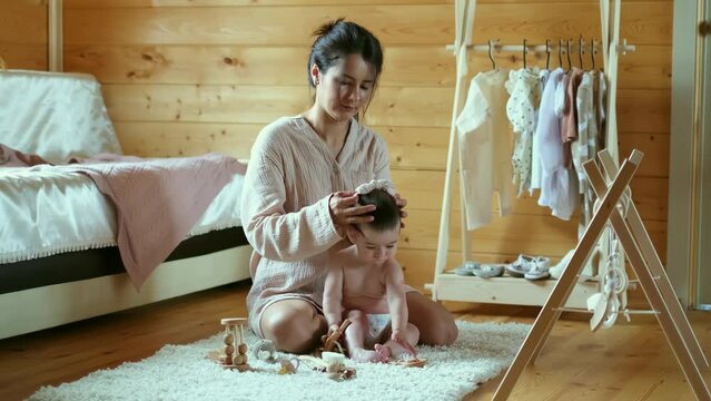 Soft light bathes a nurturing scene, where a mother styles her baby s hair. This image captures the essence of slow living and mindful parenting.