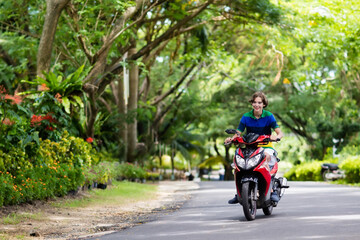 Teenager riding scooter. Boy on motorcycle.