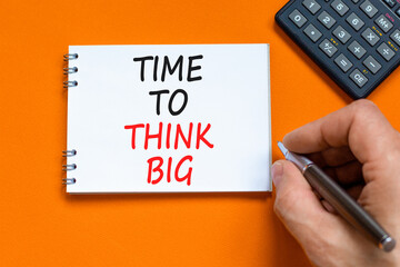 Time to think big symbol. Concept words Time to think big on beautiful white note. Beautiful orange background. Businessman hand. Calculator. Business and time to think big concept. Copy space.