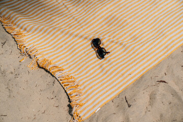 Sonnenbrille & Handtuch am Strand 