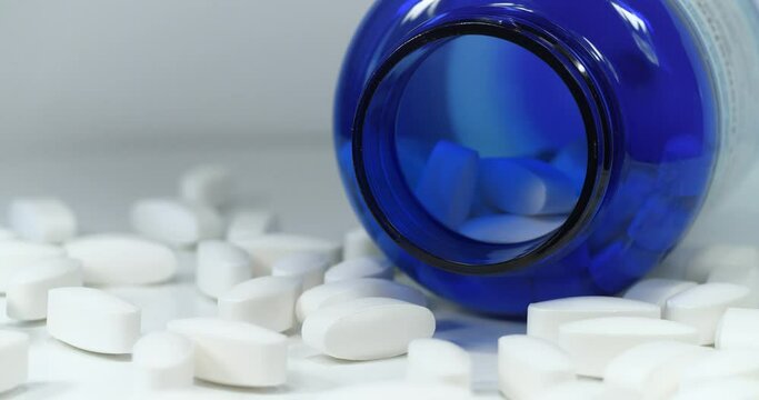 Poisoning or overdose. High doses and side effects. Pharmacological biochemistry, drug therapy. Pharmaceutical substance, drug treatment, harm from medications. Tablets and plastic jar lies on table