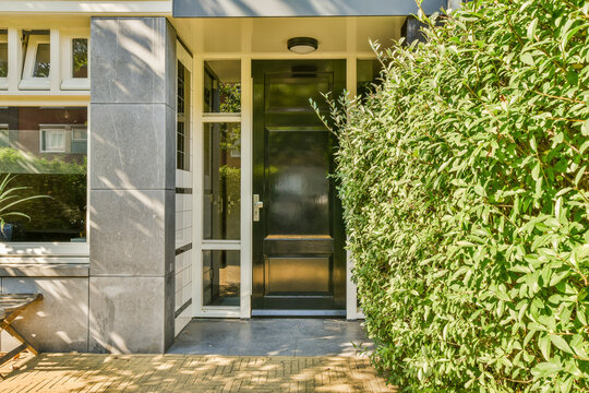 Modern home entrance with lush green hedge