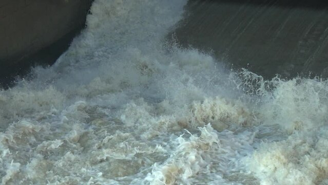 Slow Motion View of water rushing Video. Indus River Head Taunsa Barrage Gates. View of water rushing through the gates at a dam. flowing and splashing water in cold river. Beautiful 4K Footage.