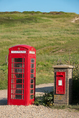 An iconic red British telephone box standing next to a post box at tourist point