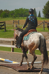 young female western rider riding rails at appaloosa youth show horse show wearing western attire...