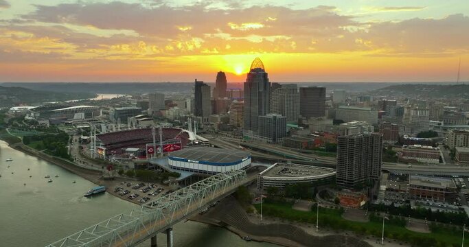 Aerial view of downtown district highway traffic in Cincinnati city, Ohio at sunset. Brightly illuminated high skyscraper buildings in modern American midtown
