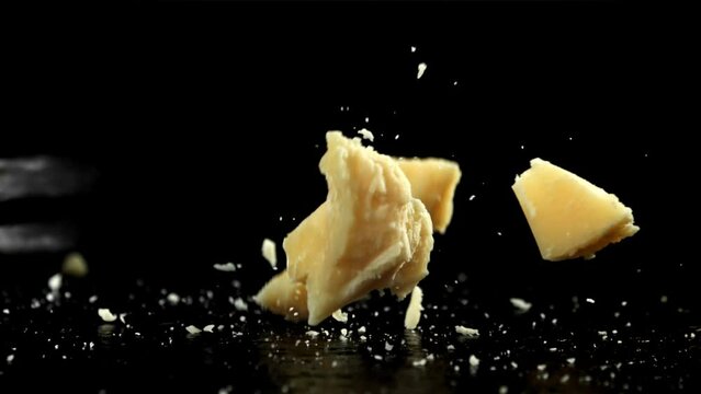 Parmesan cheese falling on a black background. Filmed on a high-speed camera at 1000 fps. High quality FullHD footage