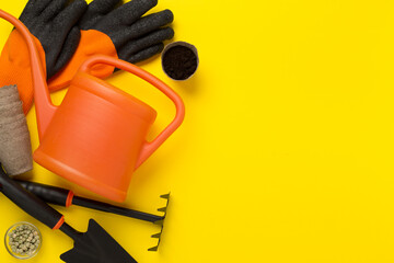 Orange gardening tools on color background, top view