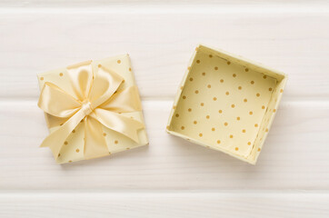 Beige open gift box on wooden background, top view