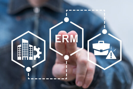 Man using virtual touch screen presses abbreviation: ERM. Enterprise Risk Management ( ERM ) Forecasting Evaluation Financial Business concept.