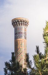 Brick minaret of the Gur Emir mausoleum with mosaic in the ancient city of Samarkand in Uzbekistan,...