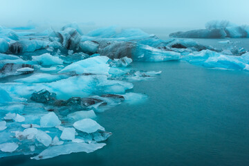 Floating iceberg of the Jokulsarlon Glacier Lagoon under heavy rain with the fog,  Iceland