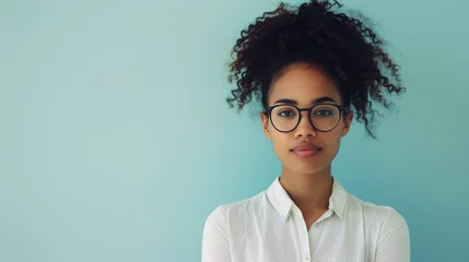 Fotobehang Young professional woman with curly hair wearing glasses © Miva