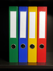 Four blank binders in green, blue, yellow and red colors