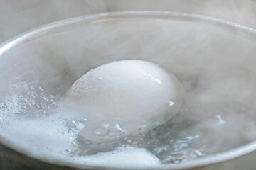 Fototapeta na wymiar close-up of a chicken white egg boiled in boiled water