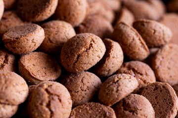 A portrait of a pile of tasty traditional dutch treats called pepernoten or pepernuts. The gingerbread snack is a tradition during the holidays and sinterklaas or saint nicholas.