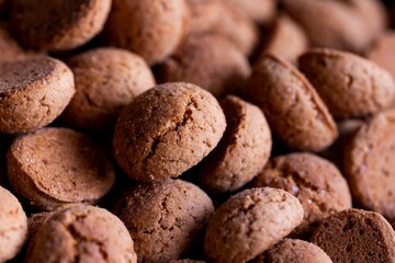 A portrait of a pile of delicious traditional dutch treats called pepernoten or pepernuts. The gingerbread snack is a tradition during the holidays and sinterklaas or saint nicholas.