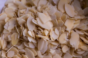 A food topdown portrait of a lot of delicious almond flakes in it used by a baker to create tasty cookies or pastries. The chopped up crunchy cooking and baking ingredient is ready to be used.