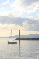 Fototapeta premium Seascape at sunshine. Lighthouse and sailings on the coast. Seaside town of Turgutreis and spectacular sunshine