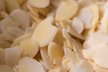 A tasty macro portrait of a pile full of almond flakes used by a baker to create tasty cookies or pastries. The chopped up crunchy cooking and baking ingredient is ready to be used.