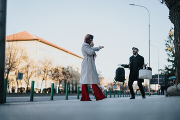 Young businessman with bags confronts phone-engrossed girlfriend on city street.