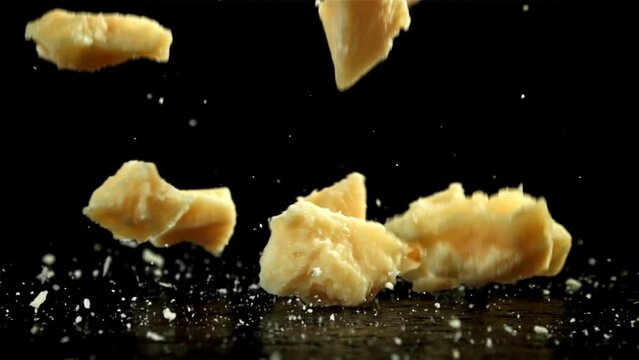 Parmesan cheese falling on a black background. Filmed on a high-speed camera at 1000 fps. High quality FullHD footage
