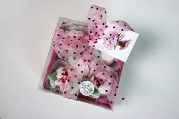 Zephyr flowers. Gift box with pink tulips and bows on a white background. Tulips from marshmallows. Homemade zephyr.