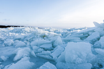 Fototapeta na wymiar Broken ice shards are on the coast of Baltic Sea on a winter day